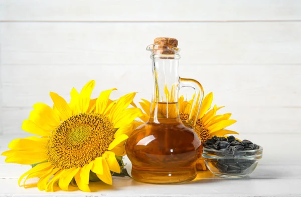Karaffe Aus Sonnenblumenöl Und Glasschale Mit Samen Auf Weißem Holzhintergrund — Stockfoto