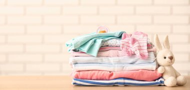 Bebek kıyafetleri, emzik ve oyuncak yığını odada. Tasarım için pankart