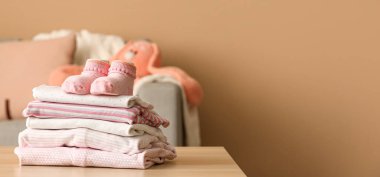 Odadaki bebek kıyafetleri ve çorapları yığını. Tasarım için pankart