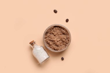 Jar with body scrub and bottle of sea salt on color background