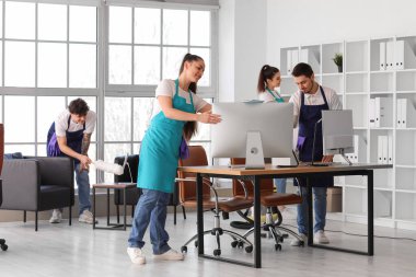 Genç hademeler ofiste temizlik yapıyor.