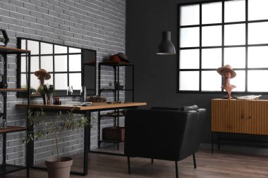 Rahat koltuğu, masası ve aynası olan bir güzellik salonu.