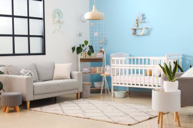 Bebek beşiği, kanepesi ve raf ünitesi olan şık bir yatak odası.