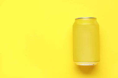 Sarı arka planda bir kutu soda.