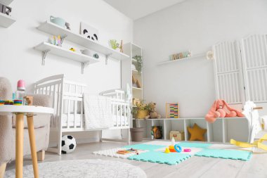 Bebek yatağı ve oyuncaklarla dolu bir çocuk odası.