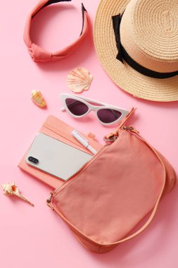 Cep telefonlu şık çanta ve pembe arka planda farklı aksesuarlar.