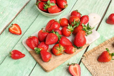 Yeşil ahşap arka planda taze çilek var.