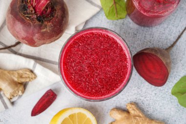 Hafif arka planda bir bardak taze pancar suyu.