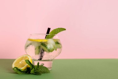 Bir bardak salatalıklı limonata ve renkli arkaplanda nane şekeri.