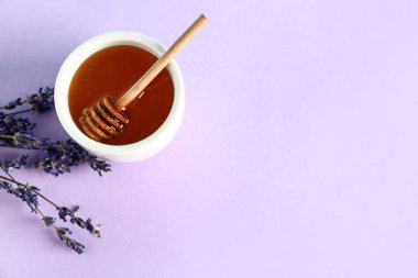 Bir kase tatlı lavanta balı, leylak arkaplanda çiçek