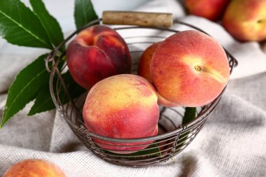 Tatlı şeftali ve yapraklı sepet, yakın plan.