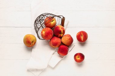 Beyaz ahşap arka planda şeftalili sepet.