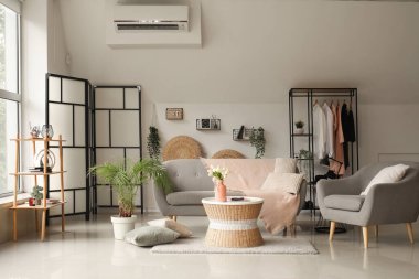 Rahat gri kanepesi, koltuğu ve sehpası olan bir oturma odası.