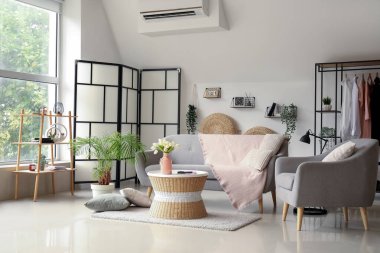 Rahat gri kanepesi, koltuğu ve sehpası olan bir oturma odası.