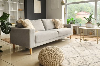 Gri kanepesi ve kahve masası olan modern oturma odasının içinde.