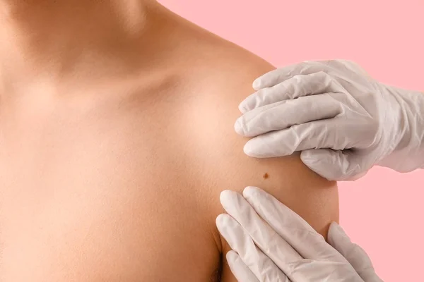 Dermatologo Esaminando Talpa Sulla Spalla Del Giovane Contro Sfondo Rosa — Foto Stock