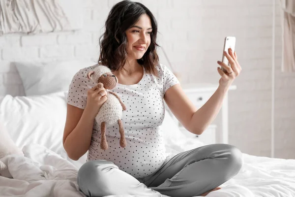 Молодая Беременная Женщина Игрушкой Помощью Мобильного Телефона Спальне — стоковое фото