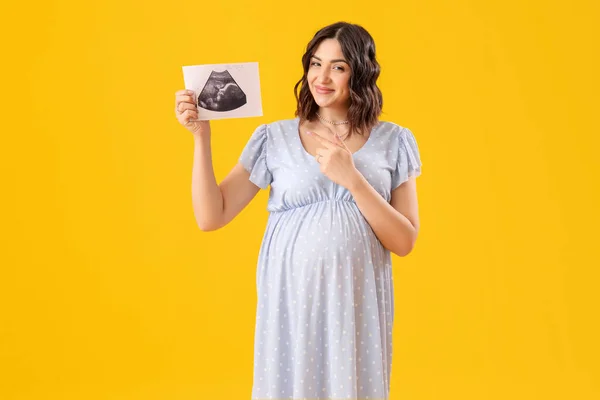 Femeie Însărcinată Tânără Care Arată Imaginea Sonogramă Fundal Galben — Fotografie, imagine de stoc