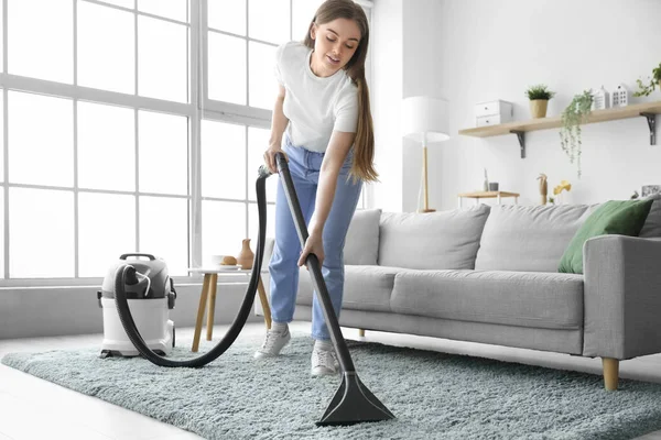 Young Woman Vacuuming Carpet Home — стоковое фото