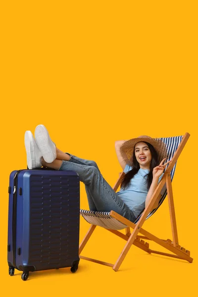 Jonge Vrouw Met Koffer Ligstoel Met Overwinningsgebaar Gele Achtergrond — Stockfoto