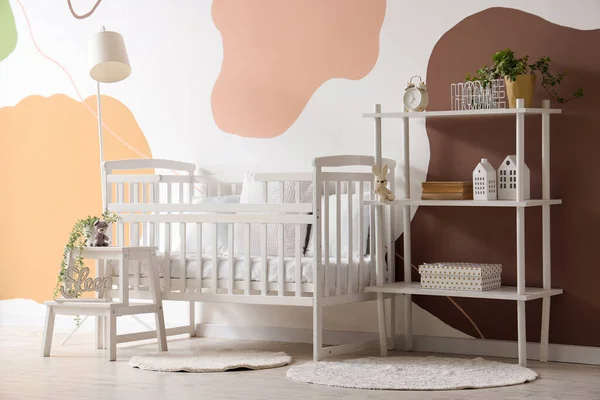 stock image Interior of stylish bedroom with baby crib and shelving unit