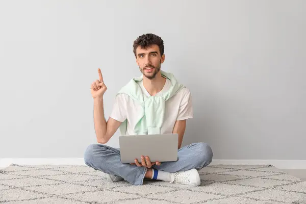 Young Man Laptop Pointing Something Light Wall — Stock Photo, Image