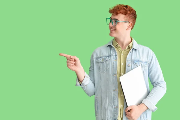 Młody Rudy Człowiek Laptopem Wskazując Coś Zielonym Tle — Zdjęcie stockowe