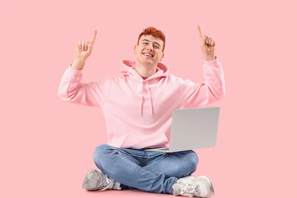 Νεαρός Κοκκινομάλλης Φορητό Υπολογιστή Που Δείχνει Κάτι Ροζ Φόντο — Φωτογραφία Αρχείου
