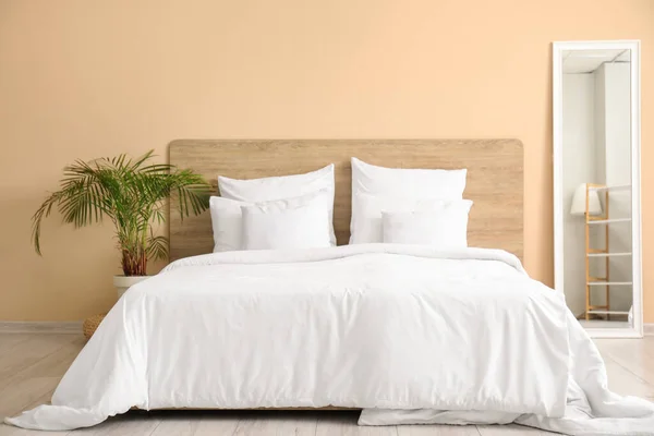 Удобная Кровать Белыми Подушками Зеркалом Домашним Растением Спальне — стоковое фото