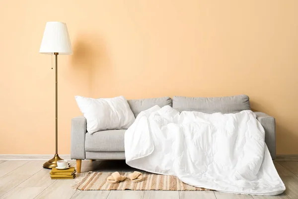 ベージュの壁の近くに白い枕と毛布が付いている灰色のソファー — ストック写真