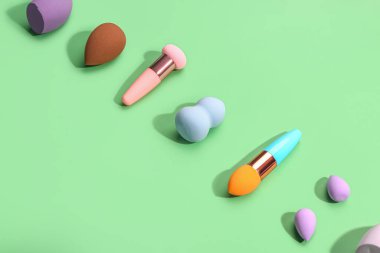 Yeşil arkaplanda farklı makyaj süngerleri