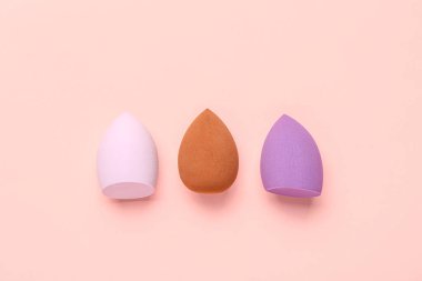 Pembe arka planda farklı makyaj süngerleri