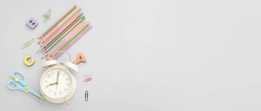 Gri zemin üzerinde okul kırtasiyesi olan ve metin için alanı olan alarm saati