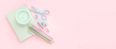 Pembe arkaplan üzerinde okul kırtasiyesine sahip alarmlı saat.