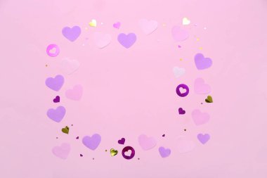 Pembe arkaplandaki kalplerden yapılmış çerçeve