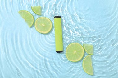 Electronic cigarette with lime in water on blue background clipart