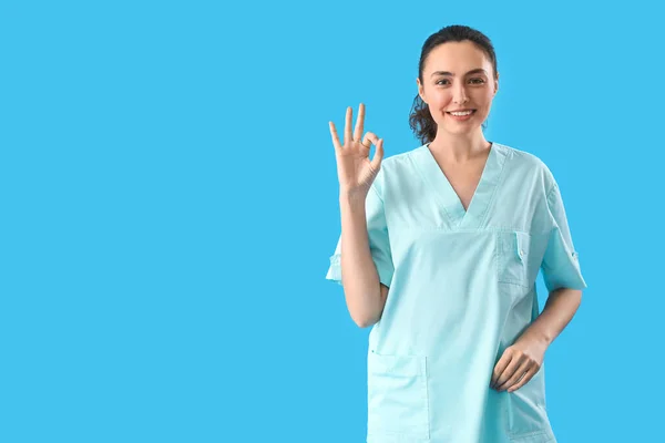 ライトブルーの背景にOkを表示する女性医療アシスタント — ストック写真