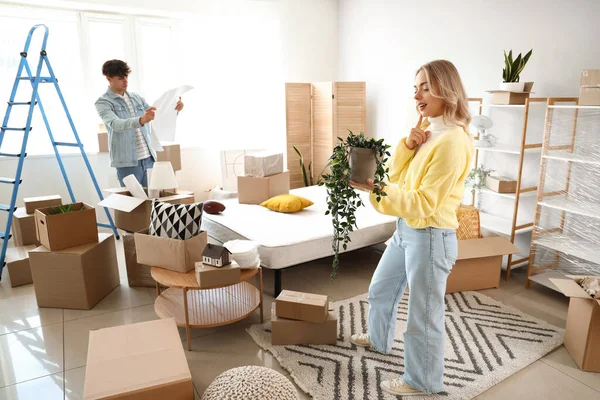 Young couple with house plan in bedroom on moving day