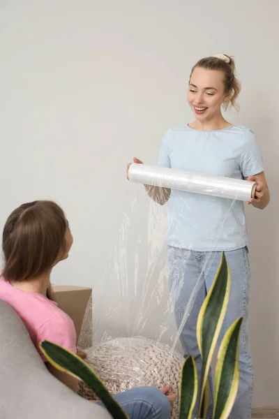 Young Women Wrapping Pouf Stretch Film Home — Stock Photo, Image