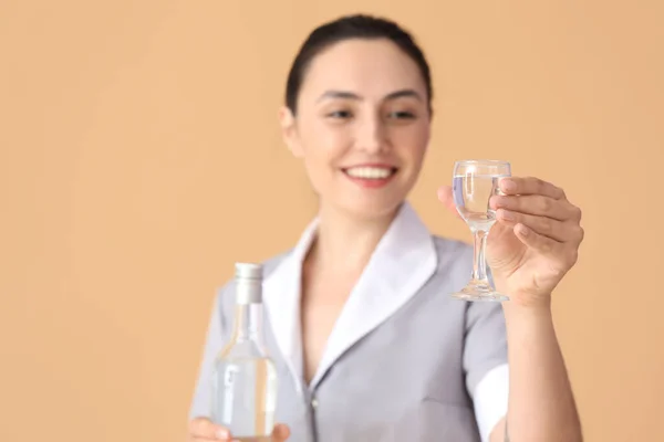 Vrouwelijke Serveerster Met Glas Fles Wodka Beige Achtergrond Close — Stockfoto