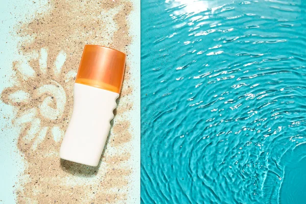 stock image Sunscreen cream on edge of swimming pool