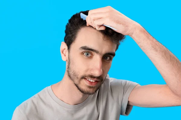 Young Brunette Man Combing Hair Blue Background Closeup — Stock Photo, Image
