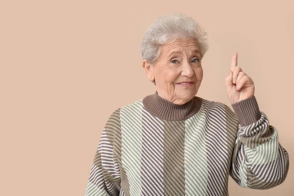 Senior Woman Pointing Something Beige Background — Stock Photo, Image