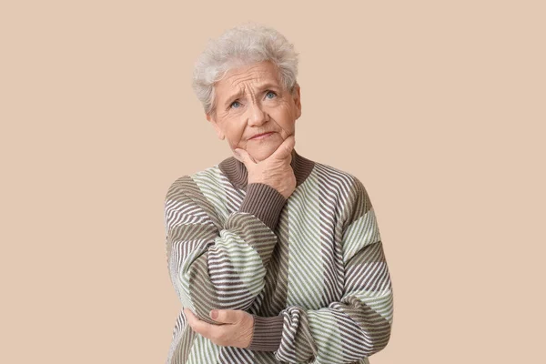 Nachdenkliche Seniorin Auf Beigem Hintergrund — Stockfoto