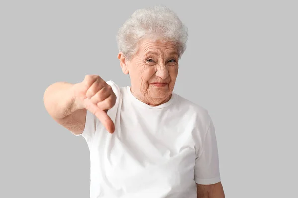 Недовольная Пожилая Женщина Показывает Большой Палец Вниз Сером Фоне — стоковое фото