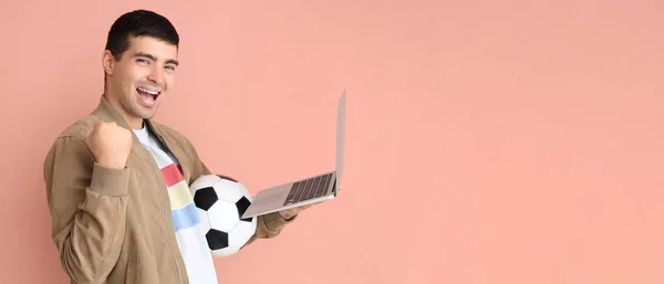 Щасливий Молодий Чоловік Футбольним Ячем Ноутбуком Рожевому Фоні Місцем Тексту — стокове фото