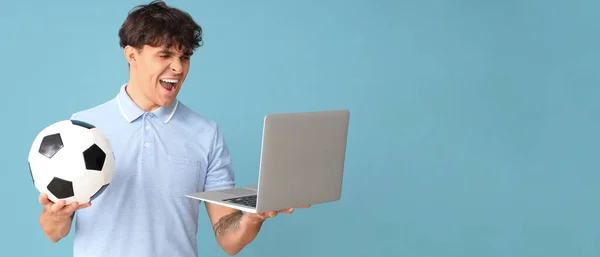 Jovem Gritando Com Bola Futebol Laptop Fundo Azul Com Espaço — Fotografia de Stock