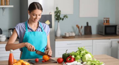 Güzel genç bayan mutfakta sebze salatası yapıyor.