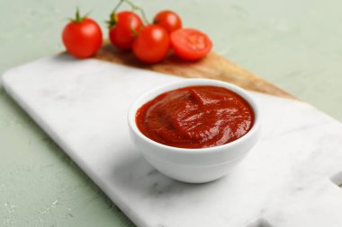 Lezzetli domates ezmesi ve yeşil grunge arka planda taze sebzelerle dolu bir pano.