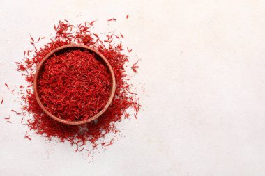 Beyaz arka planda safran yığını olan bir kase